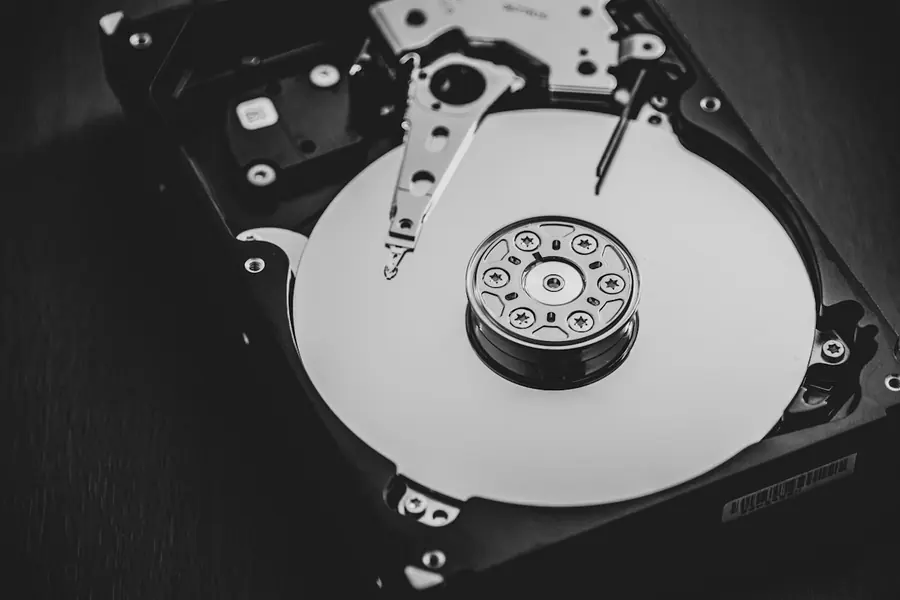 Opened hard disk drive showing the platter and read head